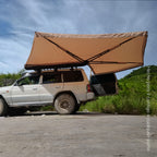 Toldo 270° Xroad abierto junto al auto en terreno