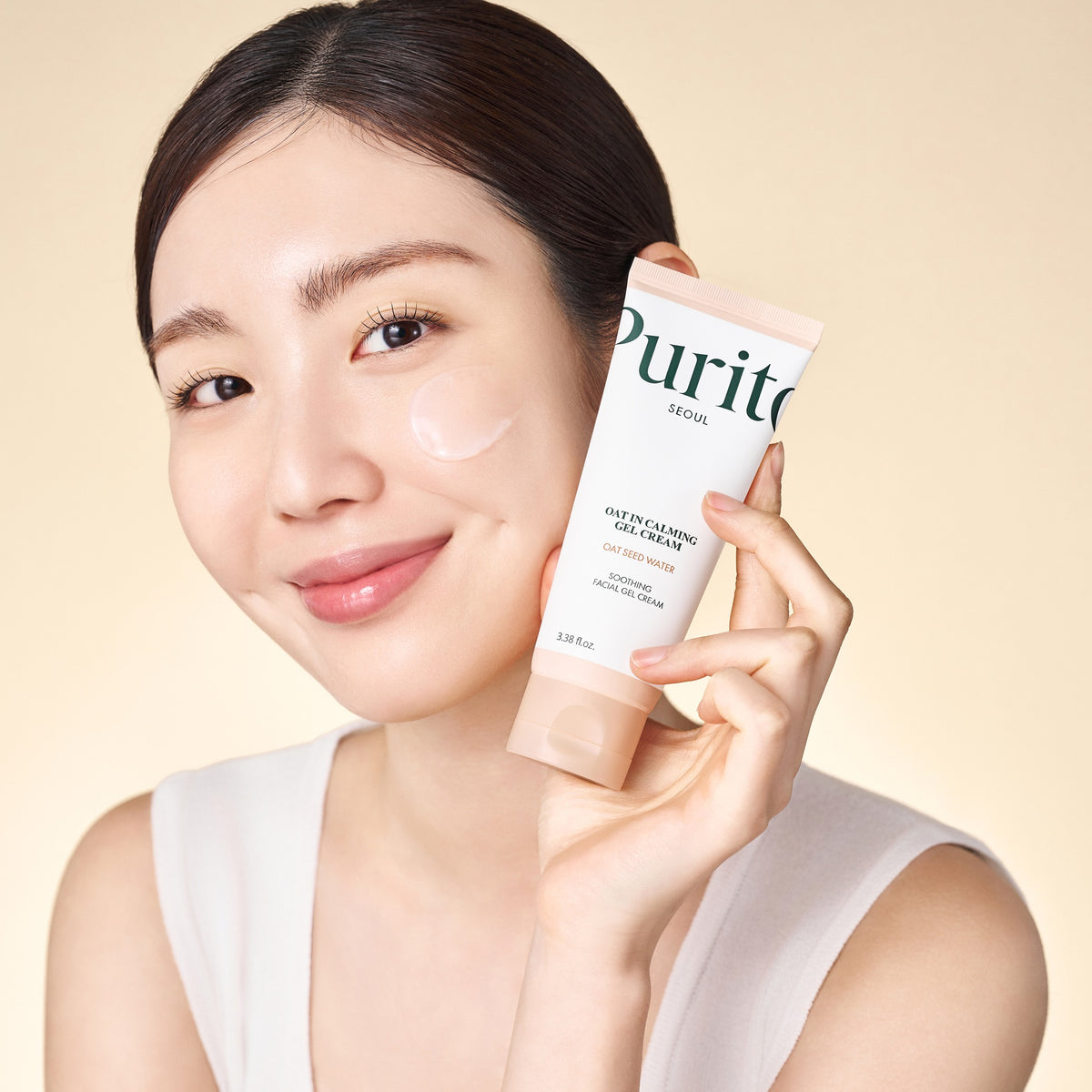 Crema Gel Facial Avena Purito Oat-In en uso, modelo sosteniendo el tubo
